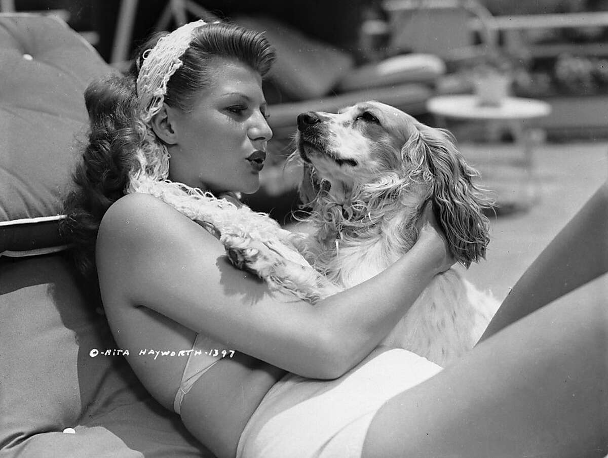 Rita Hayworth lavishes affection on her pet spaniel in 1946.