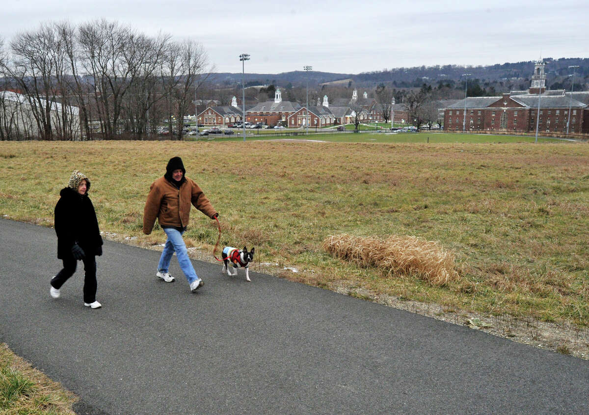 Deb and Louis Altieri walk their dog, Benny, along the trail system behind Fairfield Hills Campus in Newtown on Wednesday, Dec. 26, 2012.