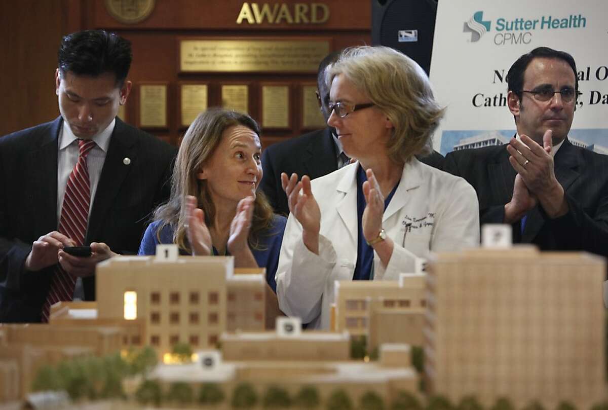 Dr. Karen Makely (second from left) and Dr. Lisa Everson (second from right) applaud speakers during a press conference at St. Lukes Hospital announcing plans to rebuild California Pacific Medical Center's healthcare facilities on Tuesday, March 5, 2013 in San Francisco, Calif.