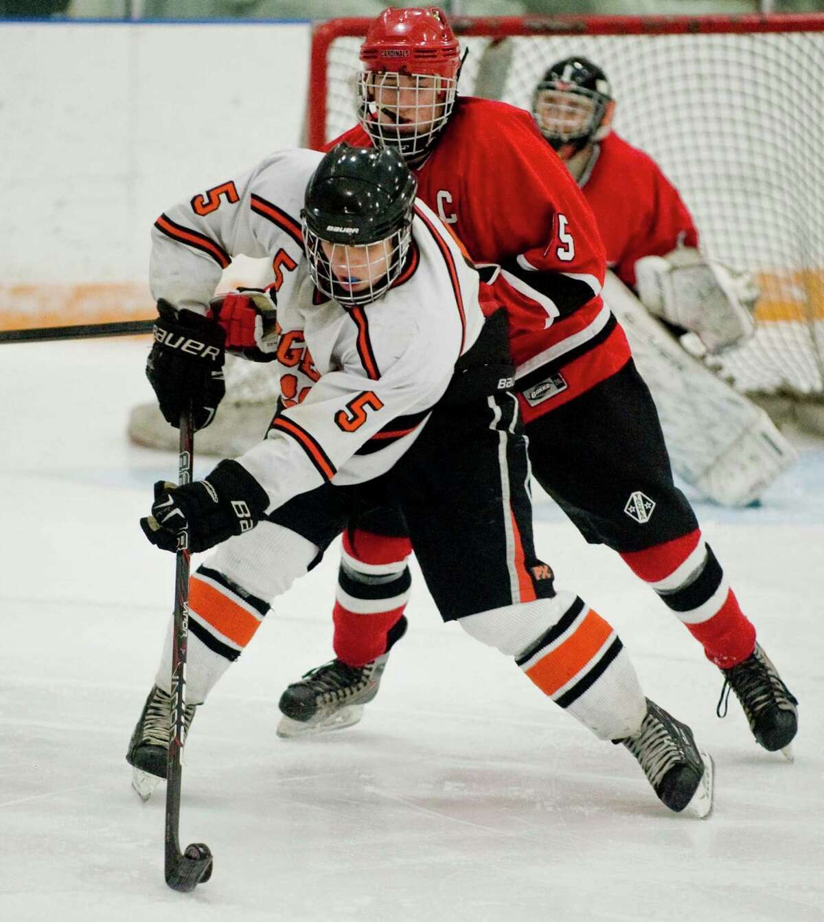 Ridgefield High School's Alex Rowella tries to manuver the puck away from Greenwich High School's Reed Brady during the division I boys ice hockey playoffs at Ridgefield. Mar. 6, 2013
