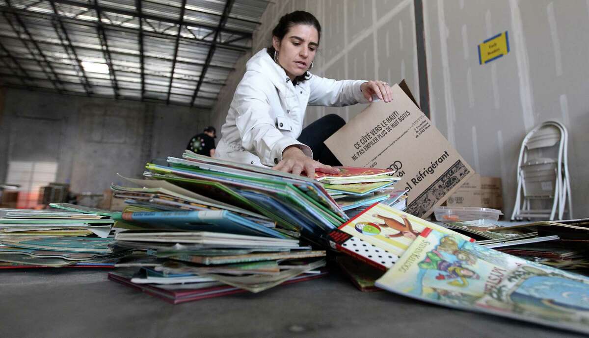 Guadalupe Harper helps box up books for the nonprofit project Books Between Kids, which was started by two River Oaks moms and has ballooned from there.