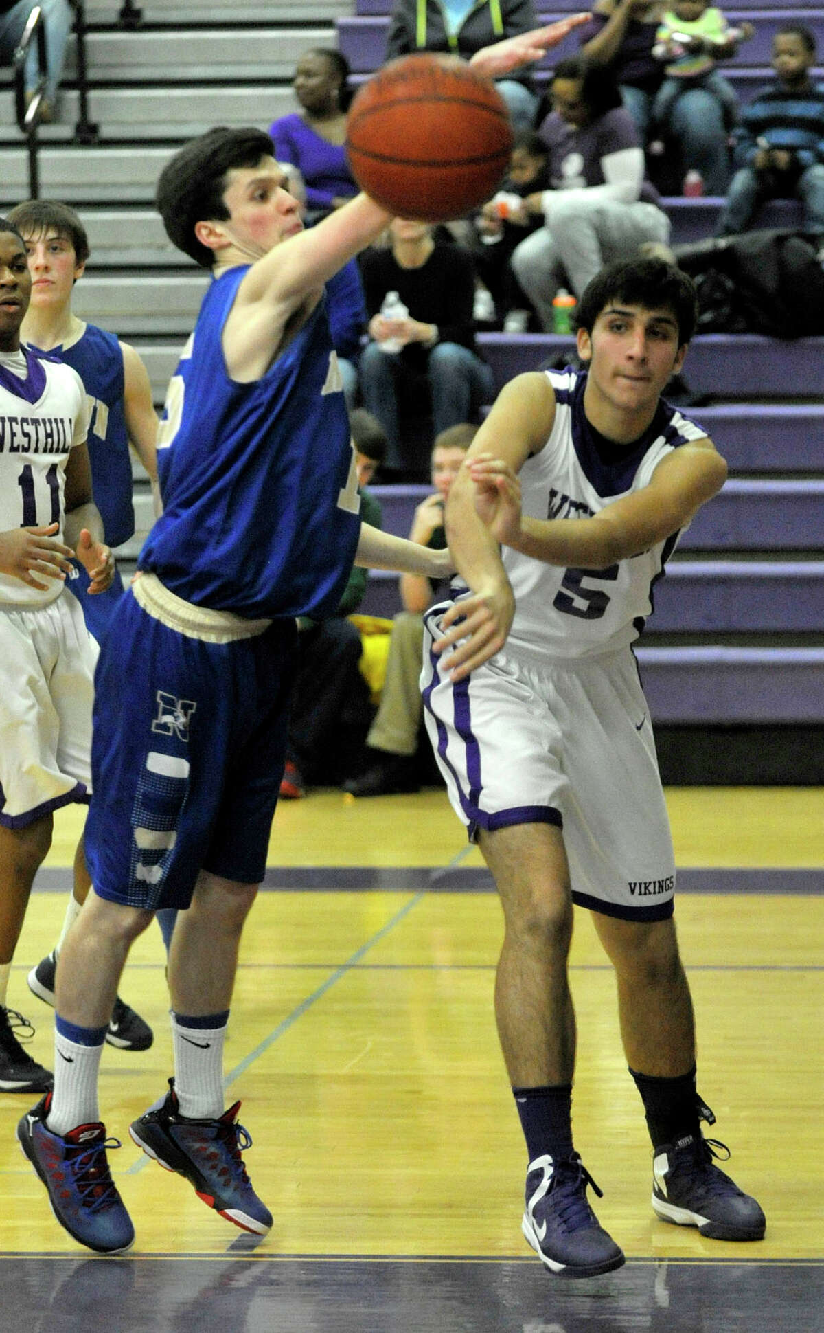 Westhill's Evan Skoparantzas passes the ball while under pressure from Newtown's Gavin Scallon during their game at Westhill High School on Wednesday, March 6, 2013.
