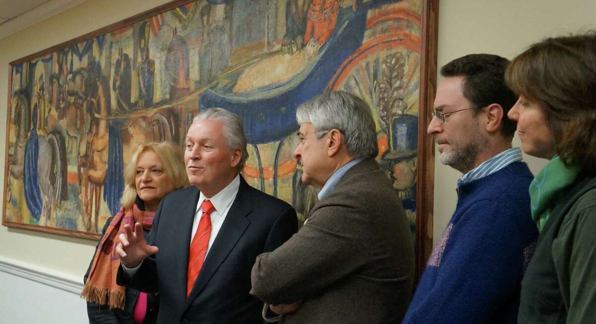 First Selectman Michael Tetreau, second from left, with members of the Fairfield Arts Advisory Committee -- from left, Ellen Hyde Phillips, Tetreau, Alan Neigher, Robert Greenberger and Sherri Steeneck -- on Thursday as a mural from the former downtown Post Office was unveiled in Sullivan-Independence Hall. FAIRFIELD CITIZEN, CT 3/7/13