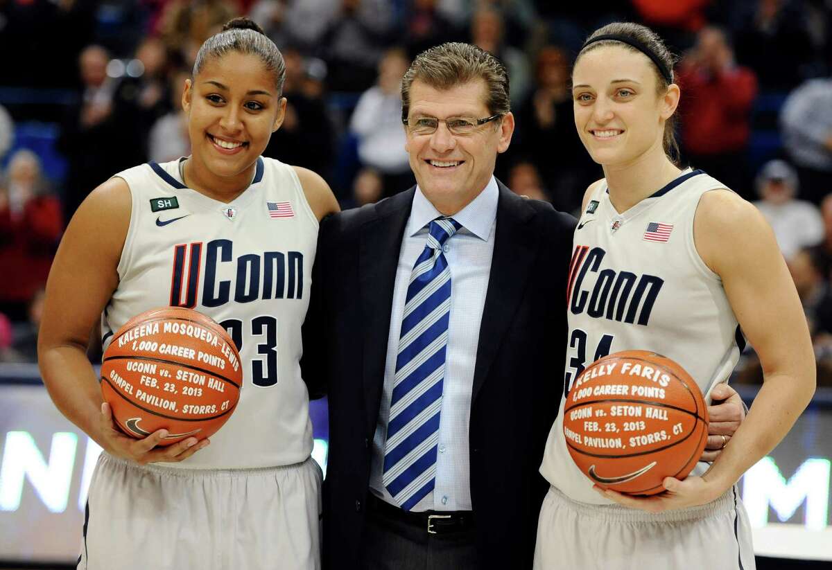 Connecticut head coach Geno Auriemma, center stands with players Kaleena Mosqueda-Lewis, left, and Kelly Faris as they are honored for both reaching the 1,000 career point mark before an NCAA college basketball game against Pittsburgh in Hartford, Conn., Tuesday, Feb. 26, 2013. (AP Photo/Jessica Hill)