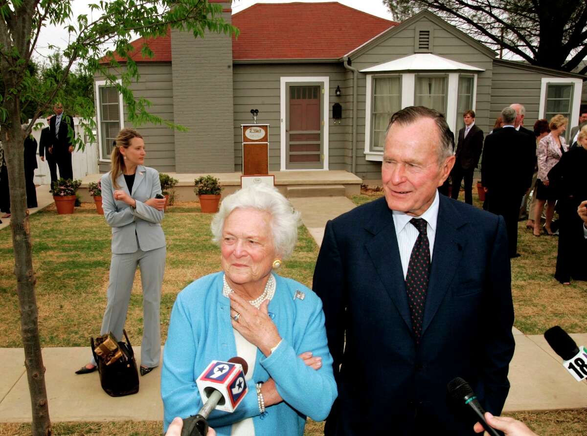 Former President George H.W. Bush, right, and Barbara Bush, left, respond to questions as they stand in front of the childhood home of George W. Bush in Midland, Texas, Tuesday, April 11, 2006. The Bushes were on hand for the official dedication of the home Tuesday.