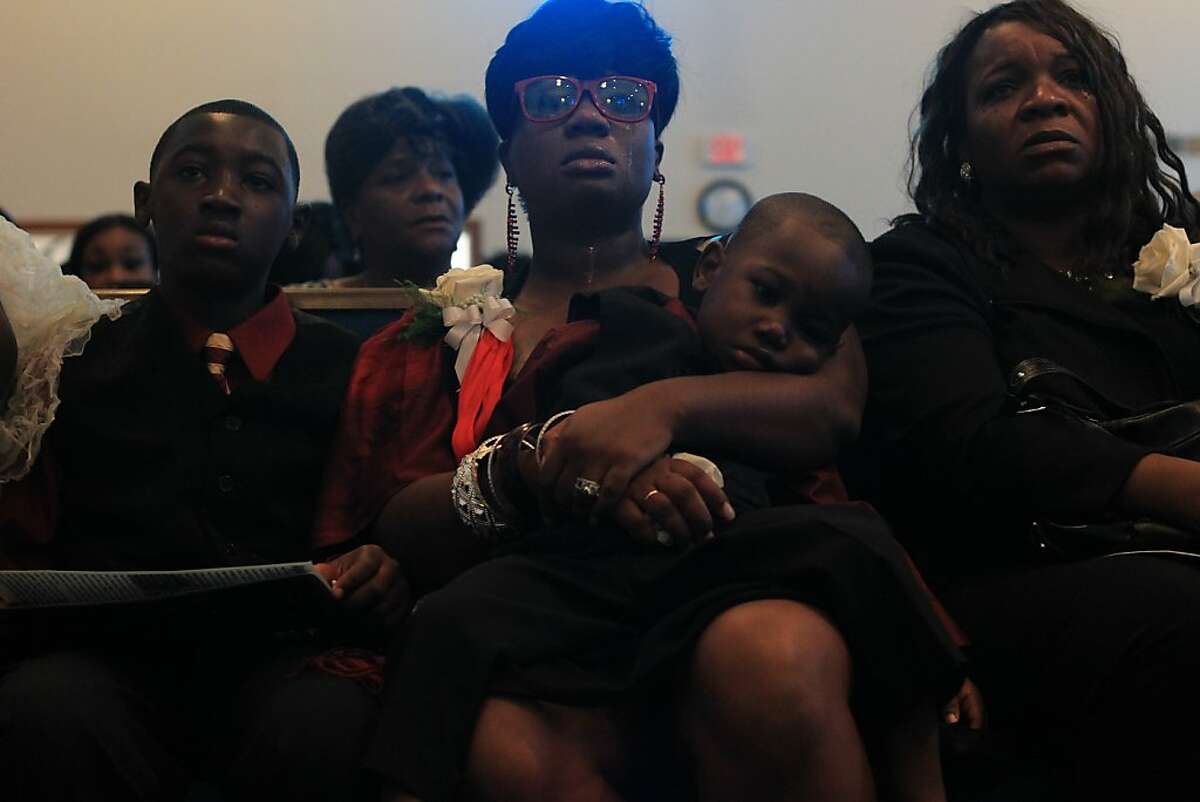 Jessica Corbray sits with two son's and family members as she listens to stories about another son, Angelo Price Corbray, 18, during his funeral on October 16, 2012, at Union Baptist Church in Oakland.