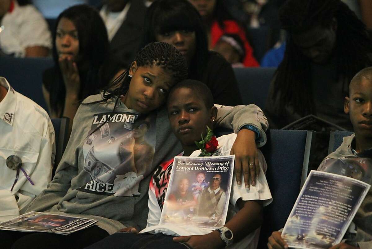 Tajjeunna Price, 15, clings to her brother Armon James, 12, as they listen to people share their memories of their brother Lamont Price during his funeral, Wednesday, February 29, 2012, at Mt. Calvary Baptist Church in Oakland.