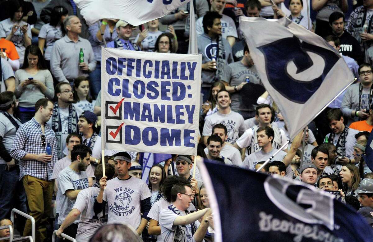 Georgetown fans hold up signs during the first half of an NCAA college basketball game between Georgetown and Syracuse, Saturday, March 9, 2013, in Washington. (AP Photo/Nick Wass)