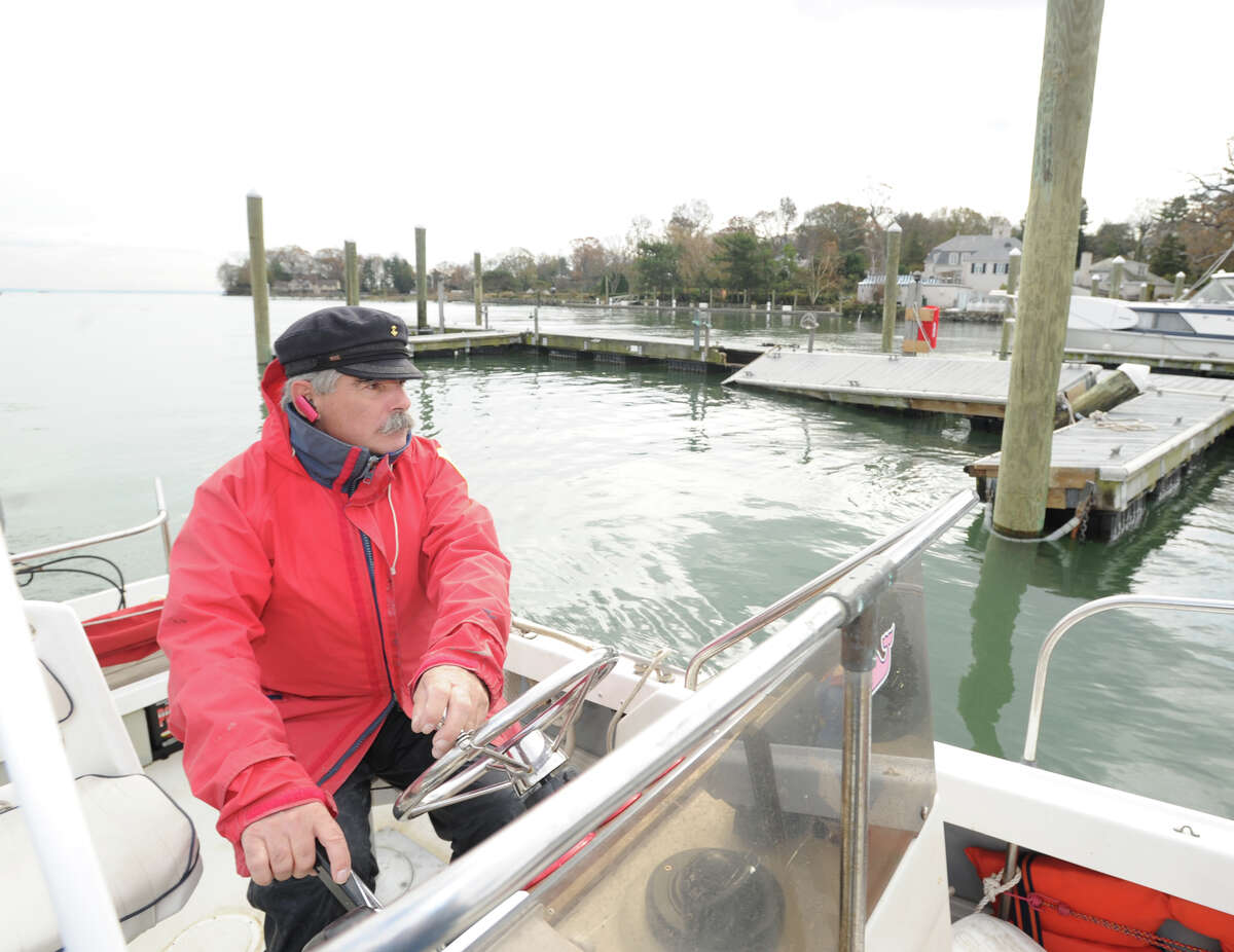 Greenwich Harbor Master Ian MacMillan views destruction caused by Hurricane Sandy in Greenwich Harbor in November. MacMillan earns $525 annually for his duties as Greenwich’s harbor master.