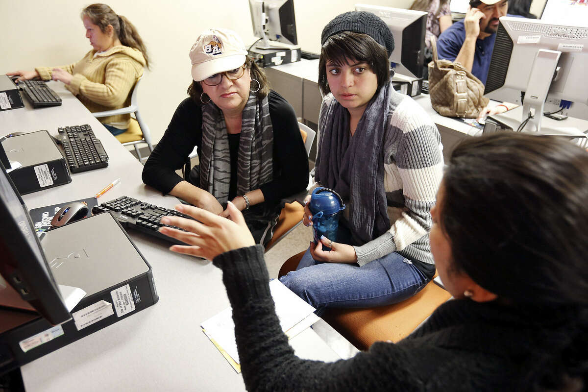 Memorial High School senior Marcie Cortinas, 18, and her mother, Alice Chavez-Cortinas, get help from Texas A&M University Senior Admissions Counselor Jennifer Aguilar during a recent Student Aid Saturdays event at Café College.
