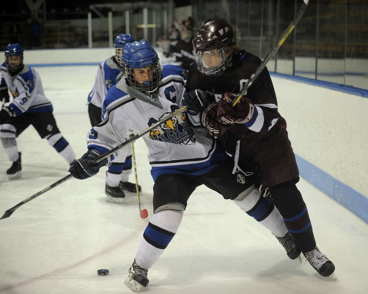 East Catholic's Vinny Genovesi, left, battles for the puck with Brookfield-Bethel-Danbury's Scott Martin in the first period of their Class 2 Semifinals matchup at the 2013 Ice Hockey State Tournament at Ingalls Rink in New Haven on Monday, March 11, 2013.
