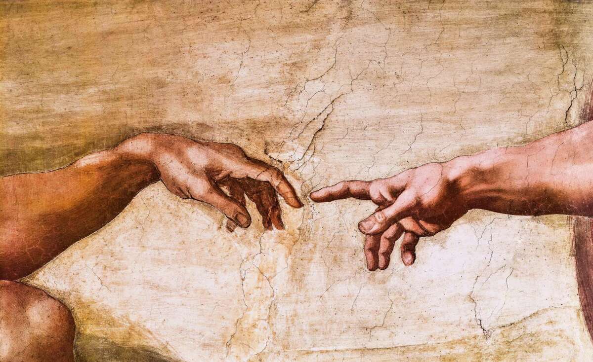 Close-up of God and Adam's hands in the Sistine Chapel.