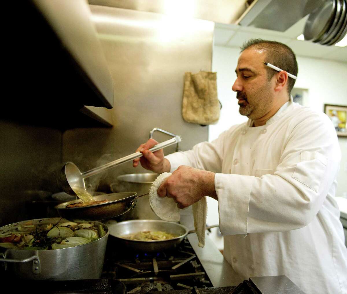 Stephen Costanzo, co-owner and head chef at Olio in Stamford, cooks in the kitchen on Tuesday, March 12, 2013.