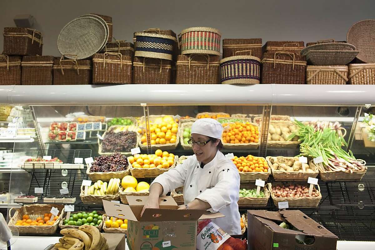 Lupita Fernadez stocks fruits at Dean and Deluca, owned by Leslie Rudd, in St. Helena, Calif., Friday, March 8, 2013.