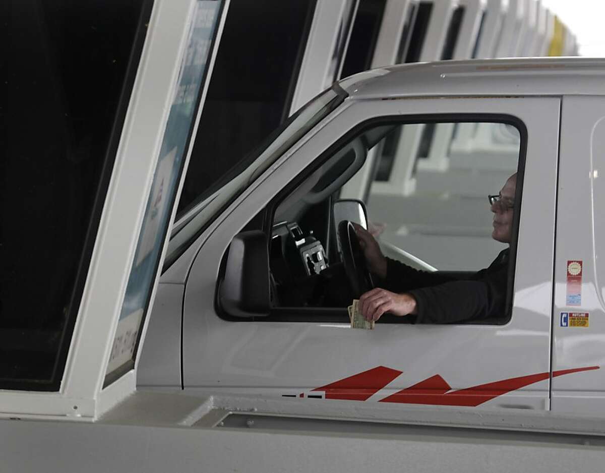 A commuter prepares to pay a $6 toll at the Bay Bridge toll plaza in Oakland, Calif. on Tuesday, March 12, 2013. Some drivers will pull over on the shoulder before the pay gates and wait until the tolls drop to $4 after 10 a.m.