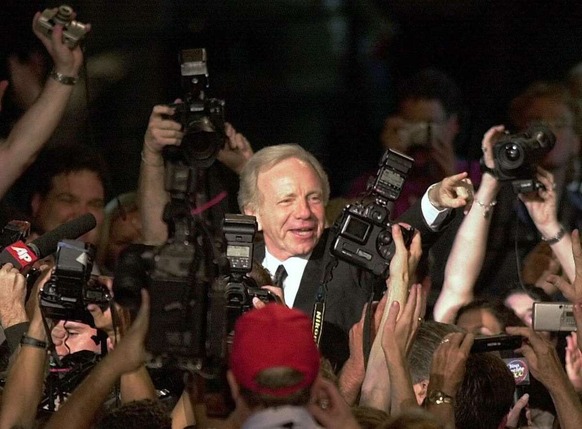 Vice presidential candidate Joe Lieberman is swarmed by photographers as he enters the Democratic National Convention in the Staples Center Tuesday, Aug. 15, 2000, in Los Angeles. (AP Photo/Ron Edmonds)