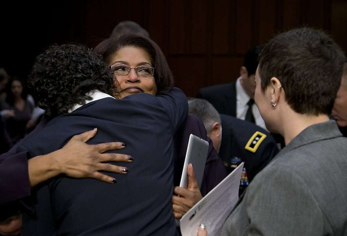 BriGette McCoy, center, former Specialist in the U.S. Army, hugs Anu Bhagwati, former Marine officer and Executive Director and Co-Founder of Service Women's Action Network, left, as Rebekah Havrilla, former Sergeant, U.S. Army, right, stands right, after they all testified on Capitol Hill in Washington, Wednesday, March 13, 2013, before the Senate Armed Services subcommittee on Personnel hearing on sexual assault in the military. (AP Photo/Carolyn Kaster)