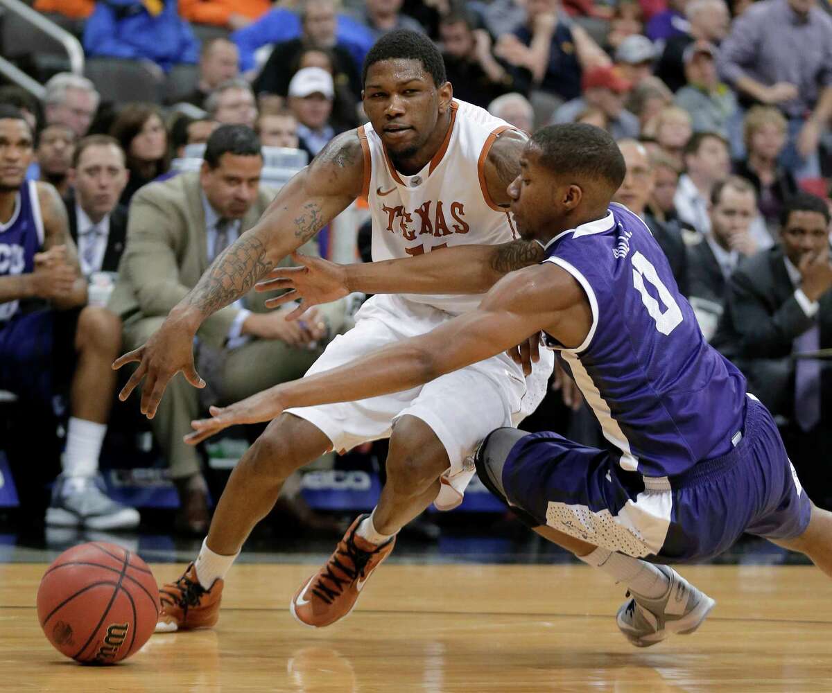 TCU guard Charles Hill Jr. (0) tries to steal the ball away from Texas guard Julien Lewis during the first half an NCAA college basketball game in the Big 12 men's tournament Wednesday, March 13, 2013, in Kansas City, Mo. (AP Photo/Charlie Riedel)