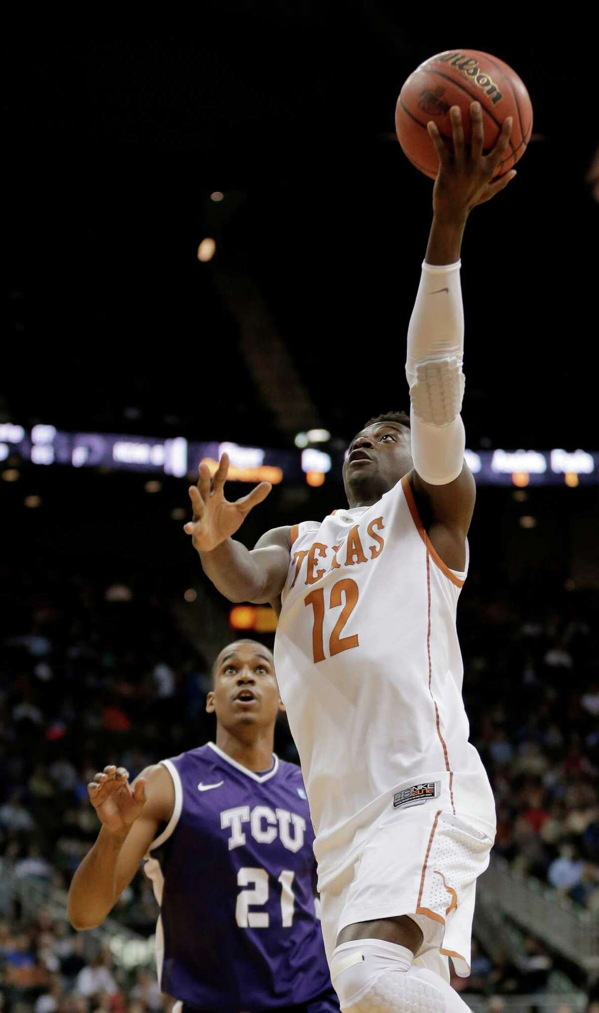 Texas guard Myck Kabongo (12) gets past TCU guard Nate Butler Lind (21) to put up a shot during the first half an NCAA college basketball game in the Big 12 men's tournament Wednesday, March 13, 2013, in Kansas City, Mo. (AP Photo/Charlie Riedel)