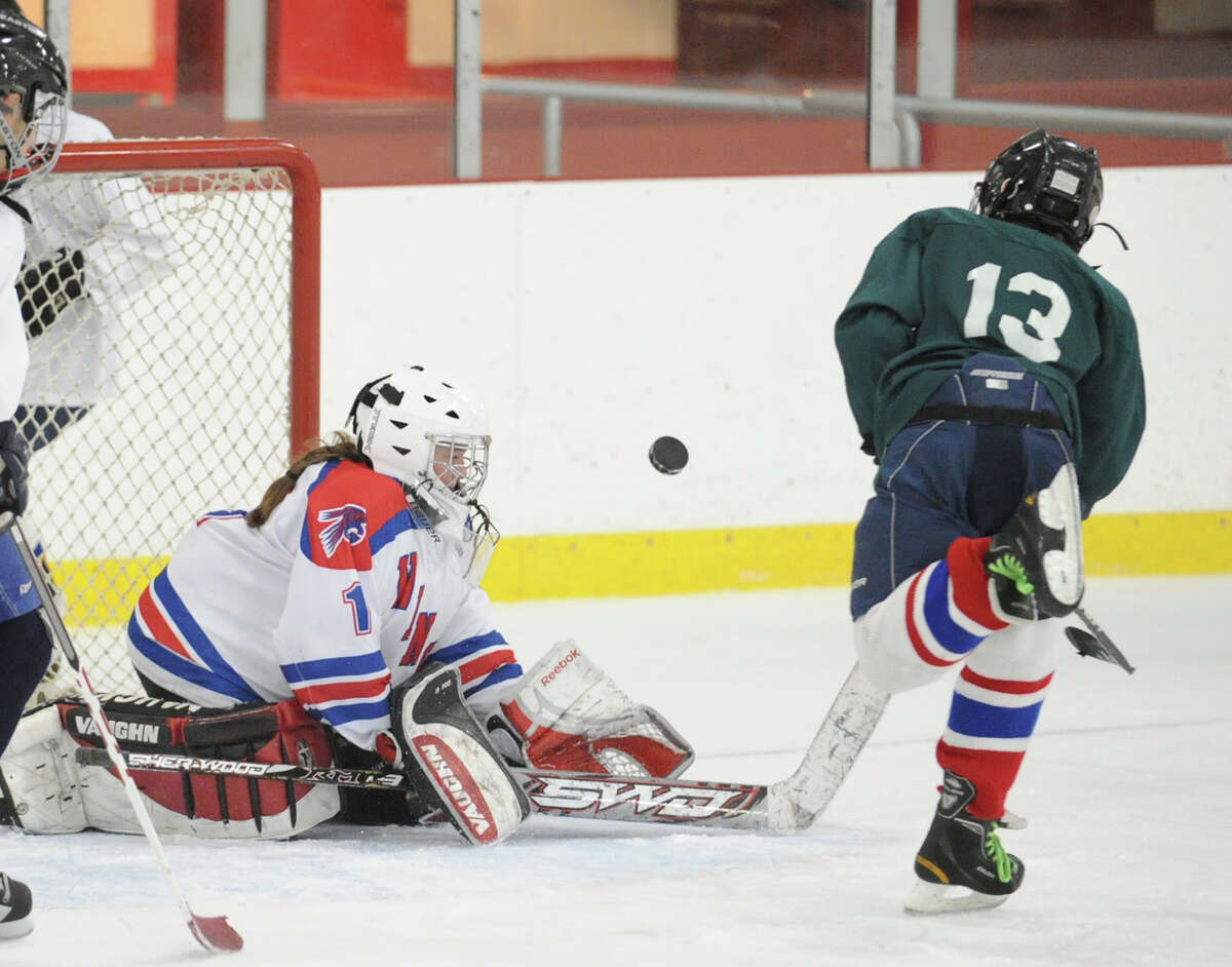 Goalie Lily Farriss of Eastern Middle School White makes a stop on Eastern Middle School Green's Connor Brust, # 13, in the Greenwich Middle School hockey challenge championship game at Hamill Rink in Byram, Wednesday, March 13, 2013. White defeated Green, 8-3.