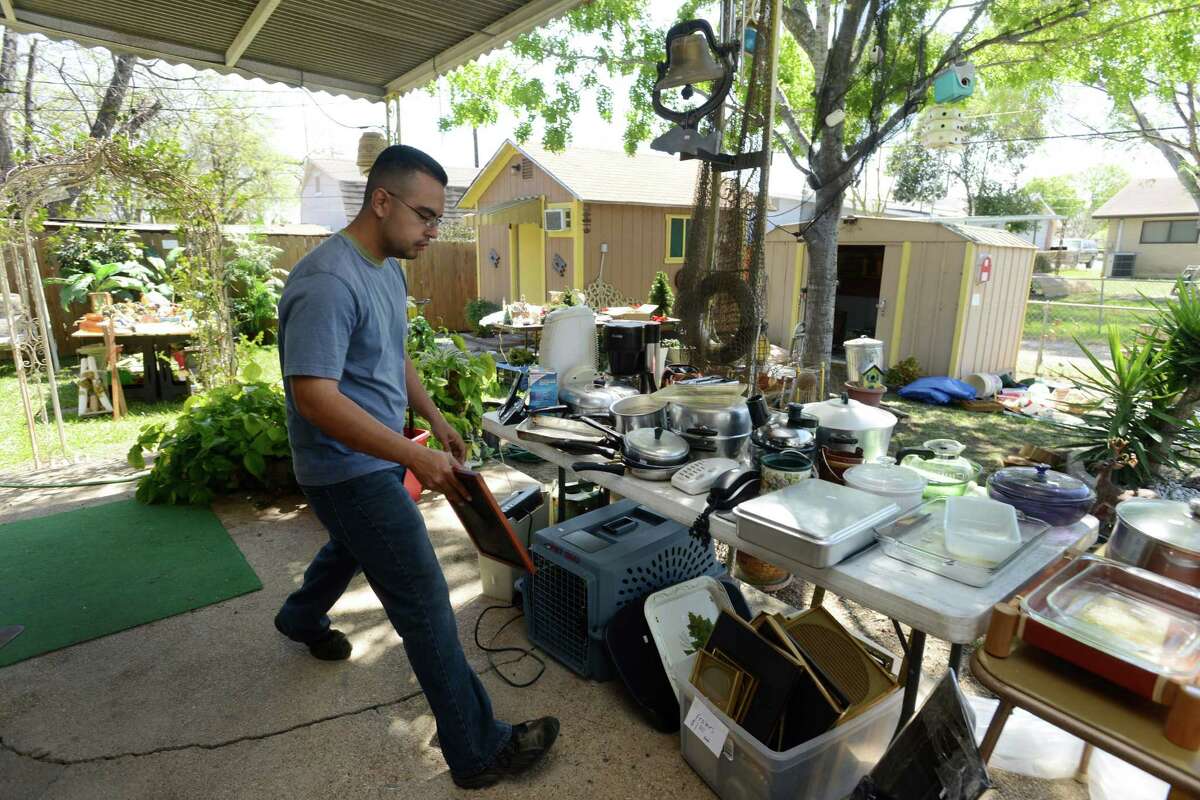Johnny Rios of Trash to Treasure works on cleaning out a South Side house where the company will have an estate sale. The company prices and organizes weekend-long events for a percentage of the sales.