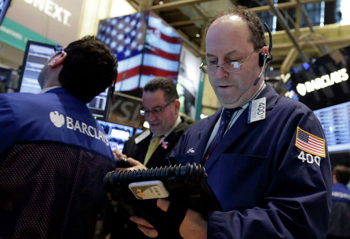 FILE -In this Tuesday, Feb. 26, 2013, file photo, Trader Gordon Charlop, right, works on the floor of the New York Stock Exchange. World stock markets shared Wall Street's ebullience and turned higher Thursday March 14, 2013 ahead of the release of U.S. jobless claims. (AP Photo/Richard Drew, File)
