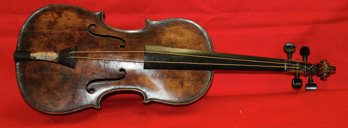 In this undated photo provided by Henry Aldridge on Friday, March 15, 2013 shows the violin that was played by the bandmaster of the Titanic as the oceanliner sank, Devizes, England. Survivors of the Titanic have said they remember the band, led by Wallace Hartley, playing on deck even as passengers boarded lifeboats after the ship hit an iceberg. Hartley?’s violin was believed lost in the 1912 disaster, but auctioneers Henry Aldridge & Son say an instrument unearthed in 2006 has undergone rigorous testing and proven to be Hartley?’s. The auction house said has spent the past seven years and thousands of pounds determining the water-stained violin?’s origins, consulting numerous experts including government forensic scientists and Oxford University. (AP Photo/Henry Aldridge)