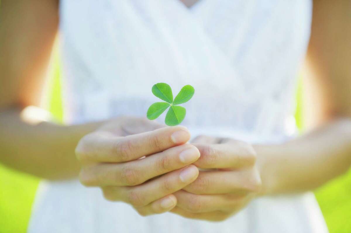 Woman holding four-leaf clover