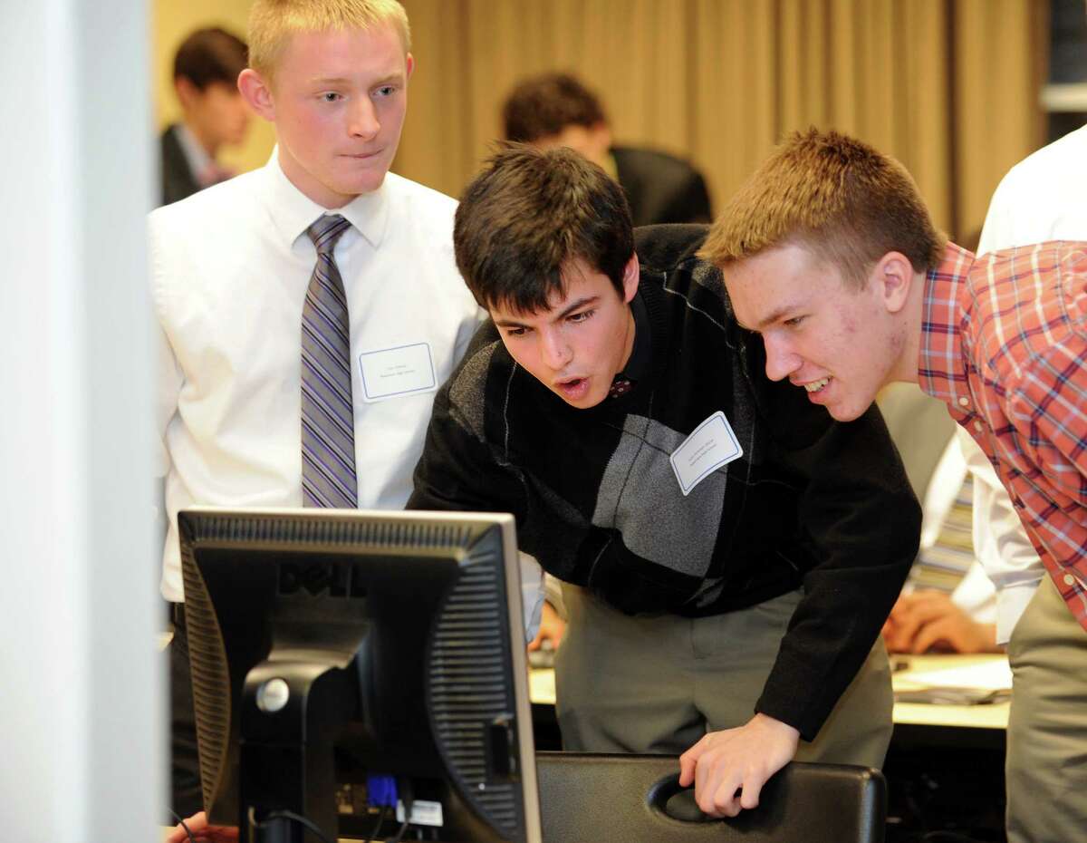 Tyler Gibney, Yossi Kohrman-Glaser and Jay DeStories, from left, seniors from Newtown High School, collaborate on a problem during the third annual Junior Achievement competition for high school student teams at the Dolan School of Business at Fairfield University Friday, Mar. 15, 2013.