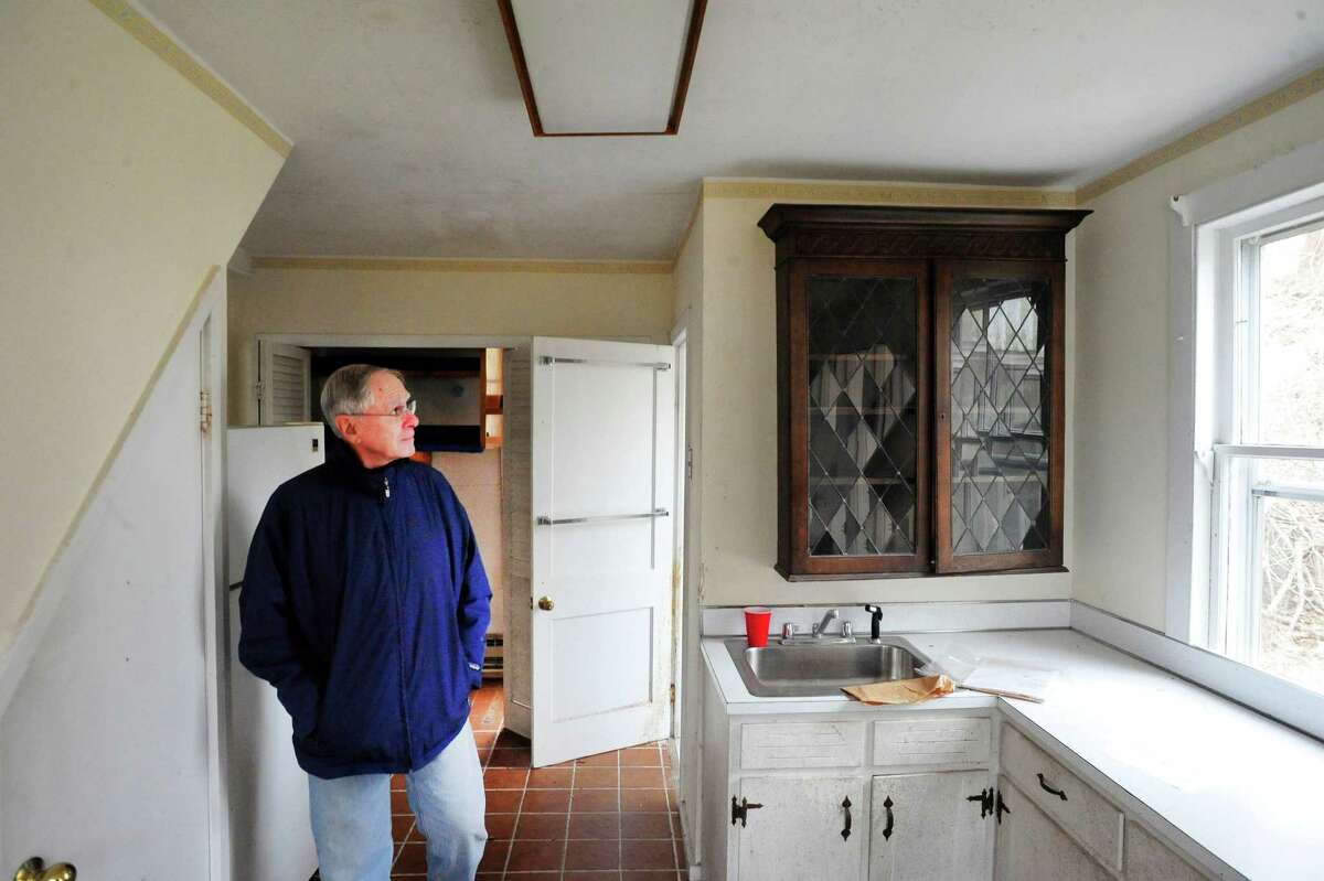 Paul McIlvaine looks at the town-owned cottage on the property up for auction in the Brookfield historic zone Saturday, March 16, 2013 in Conn.