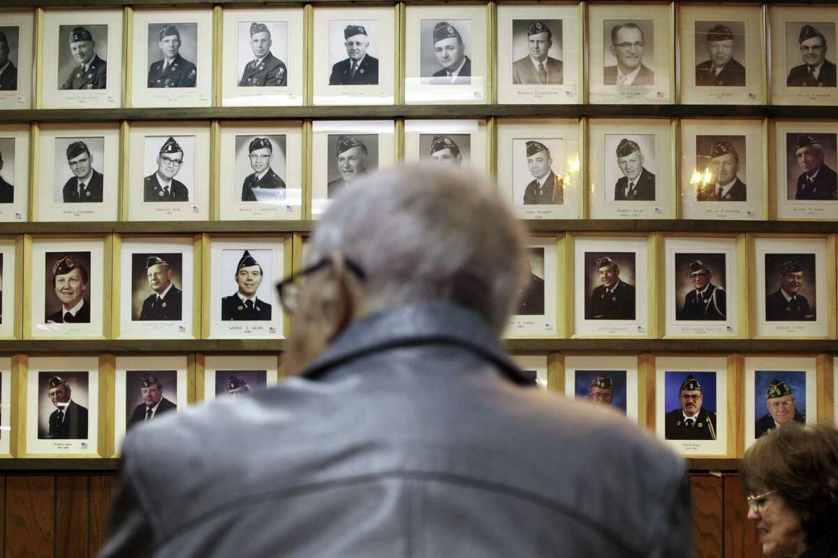 Portraits of past commanders line a wall at American Legion Post 57 in Elgin, Ill., where membership is down dramatically.