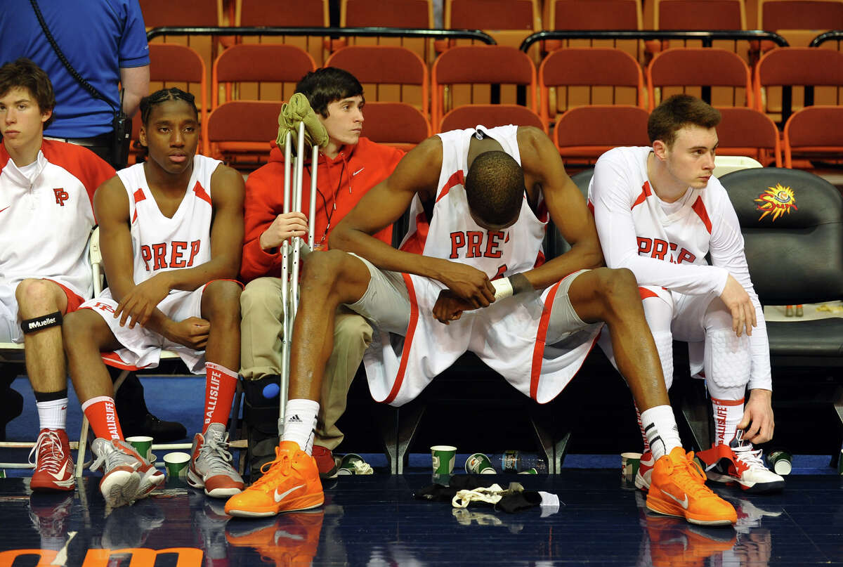 Fairfield Prep's #44 Paschal Chukwu, second from right, sits dejected with the rest of the team on the bench after being defeated by Hillhouse in Class LL boys basketball final action in Uncasville, Conn. on Saturday March 16, 2013.