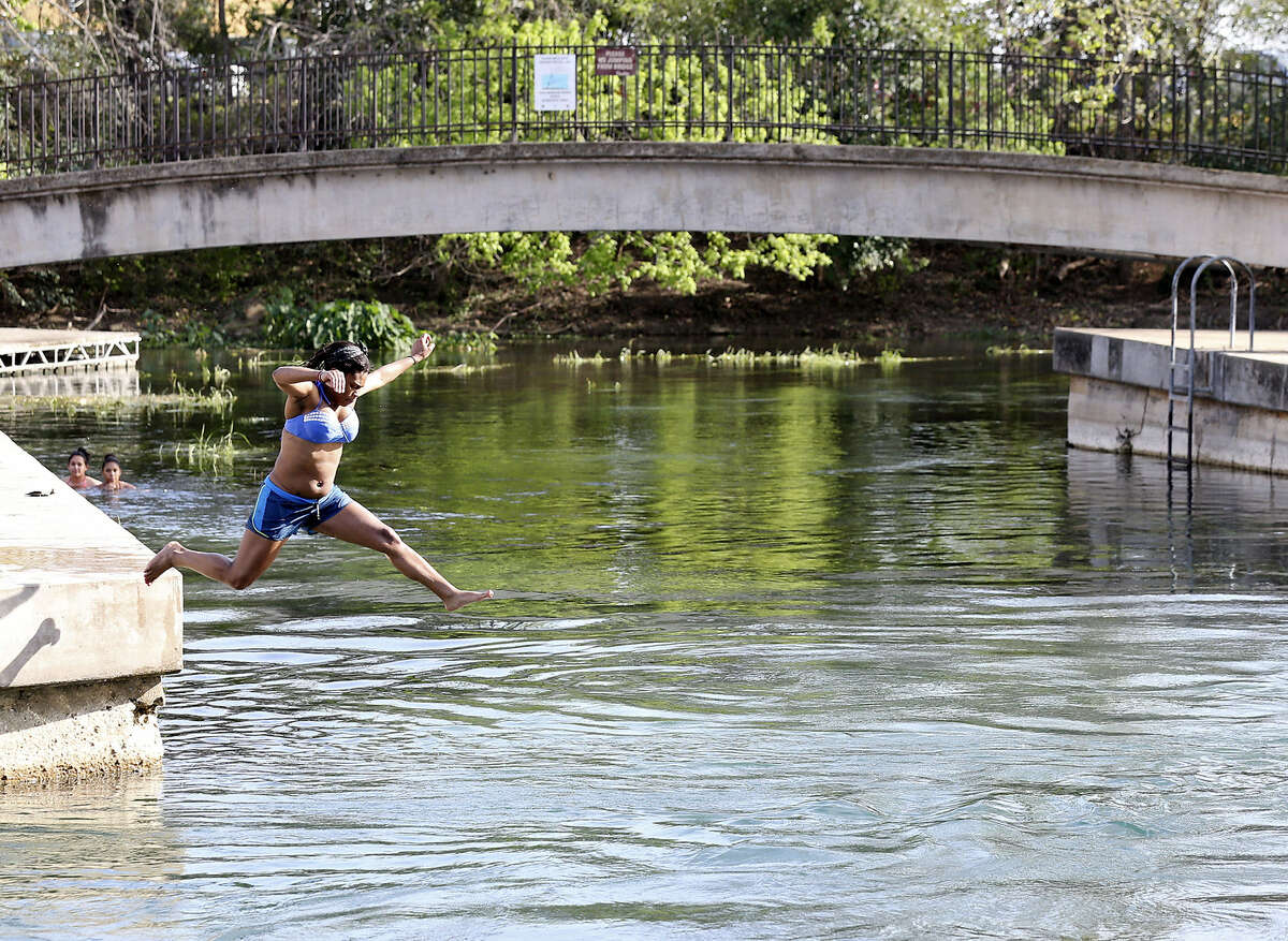 Chellese Brown takes advantage of the heat with a jump in the San Marcos River at Sewell Park in San Marcos.