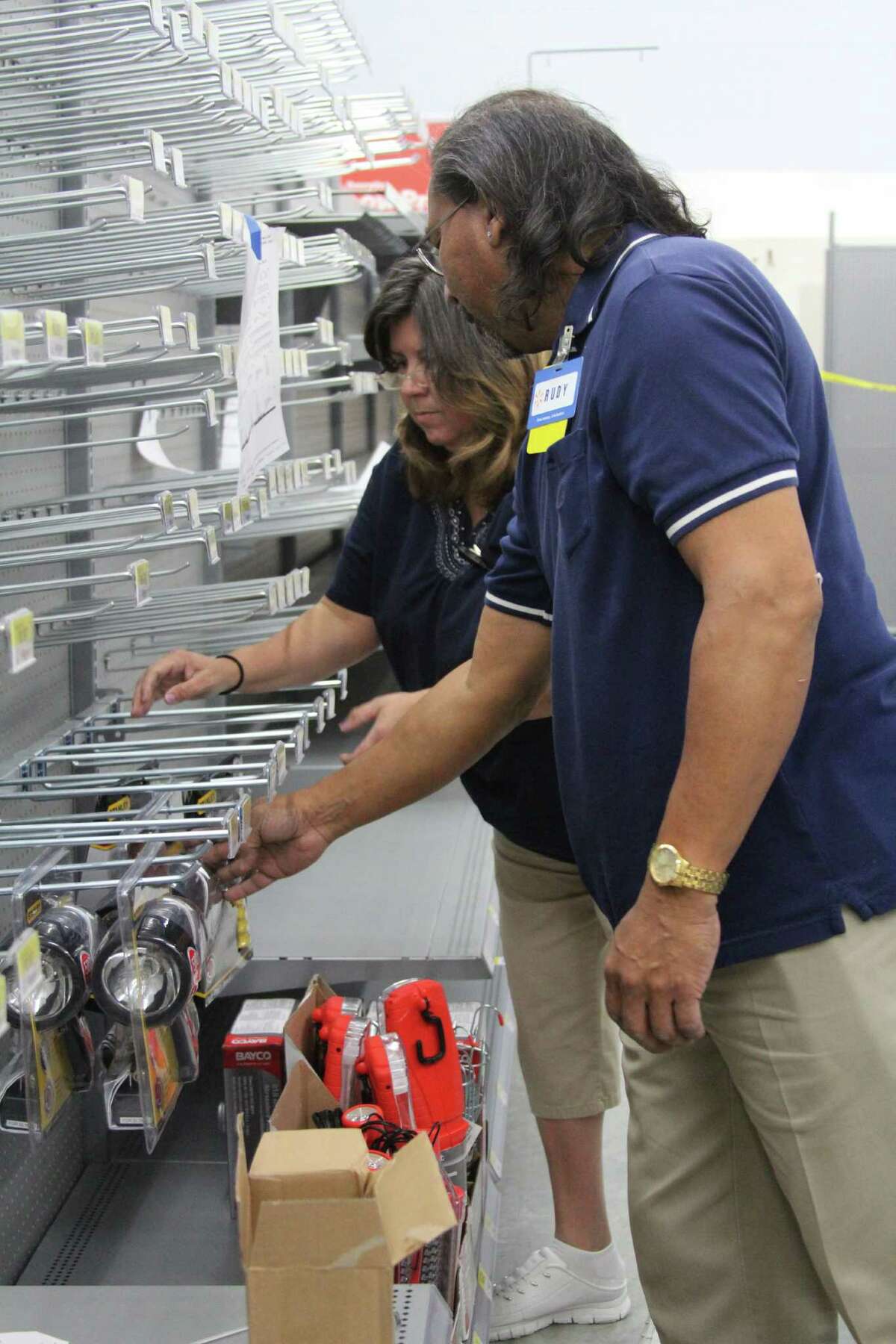 Walmart employees Aggie Rosas and Rudy Avila stock the automotive department shelves as they prepare for the April 10 opening of a new Walmart in Helotes.