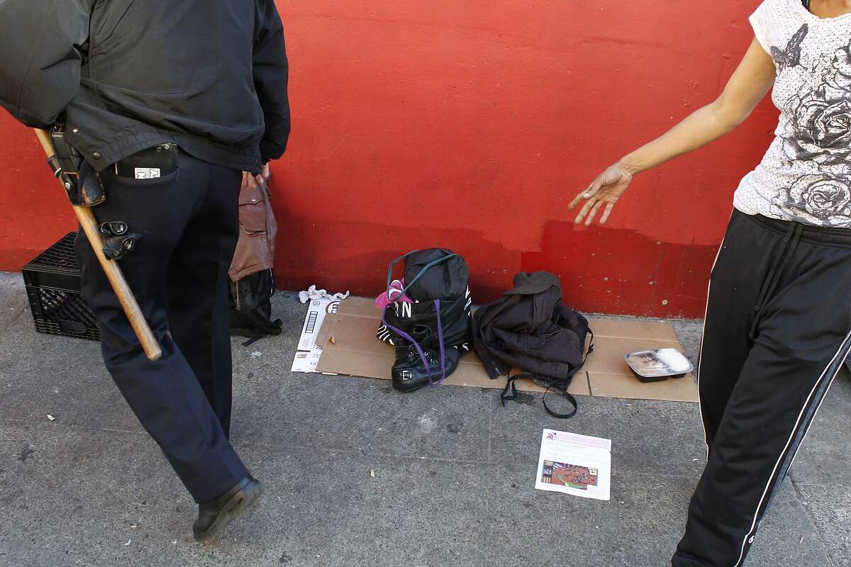 San Francisco police officer Barry Mlaker looks for alcohol in peoples' belongings on Turk Street as he and his parnter officer James Tacchini walk their beat near Market Street in San Francisco, Calif., looking for chronic law breakers on Wednesday, November 14, 2012.