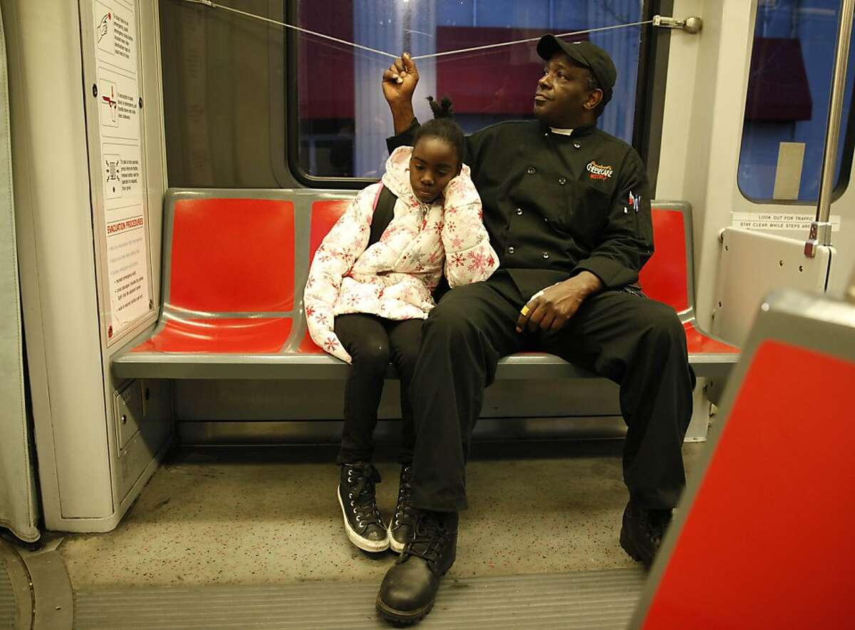 Thomas Bailey (right) signals to get off at the next stop as he rides on the T Muni light rail with his daughter, Ashanti Bailey (left), 10, to school on Wednesday, March 20, 2013 in San Francisco, Calif.