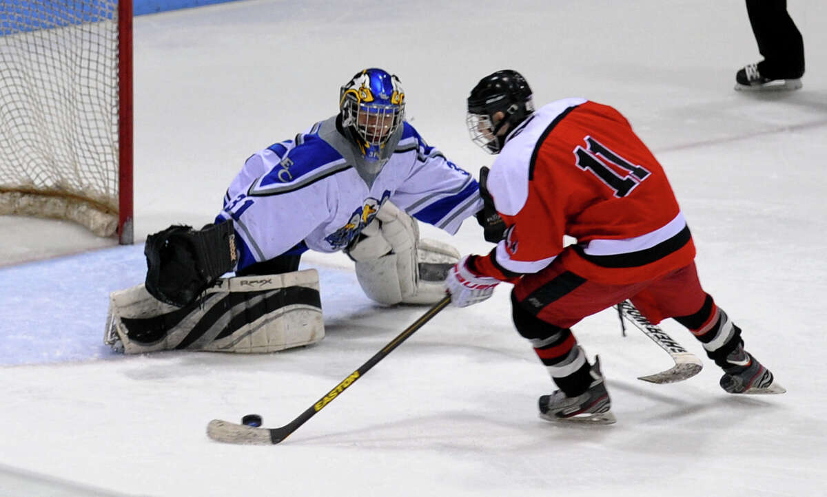 Fairfield Warde/Ludlowe Mustang's #11 Kevin Robinson manuevers the puck for a penalty goal shot past East Catholic goalie Thomas Usseglio, during fourth period overtime of CIAC Division II boys hocksey state final action at Ingalls Rink in New Haven, Conn. on Wednesday March 20 2013. Robinson made the shot giving Fairfield the win.