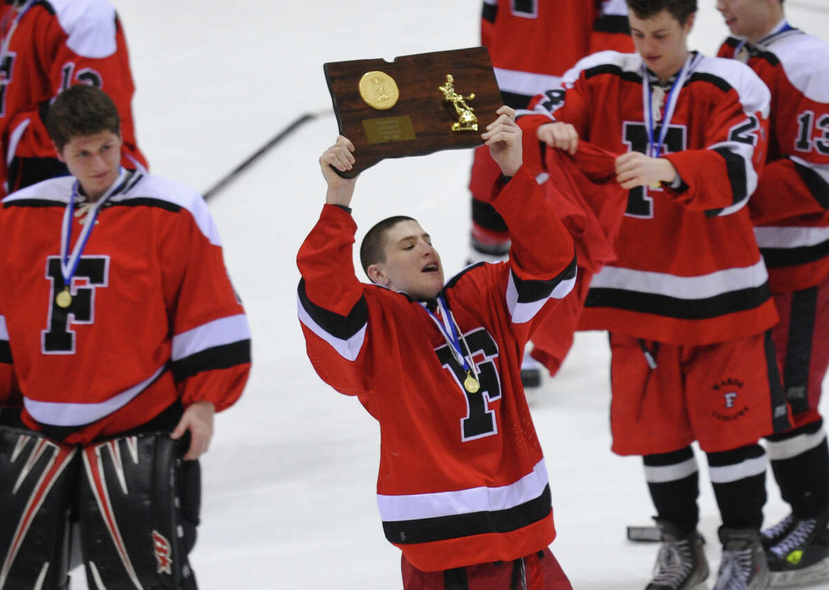 Fairfield Warde/Ludlowe Mustang's #11 Kevin Robinson proudly holds up the CIAC Division II trophy after the team beat East Catholic, during CIAC Division II boys hocksey state final action at Ingalls Rink in New Haven, Conn. on Wednesday March 20 2013.