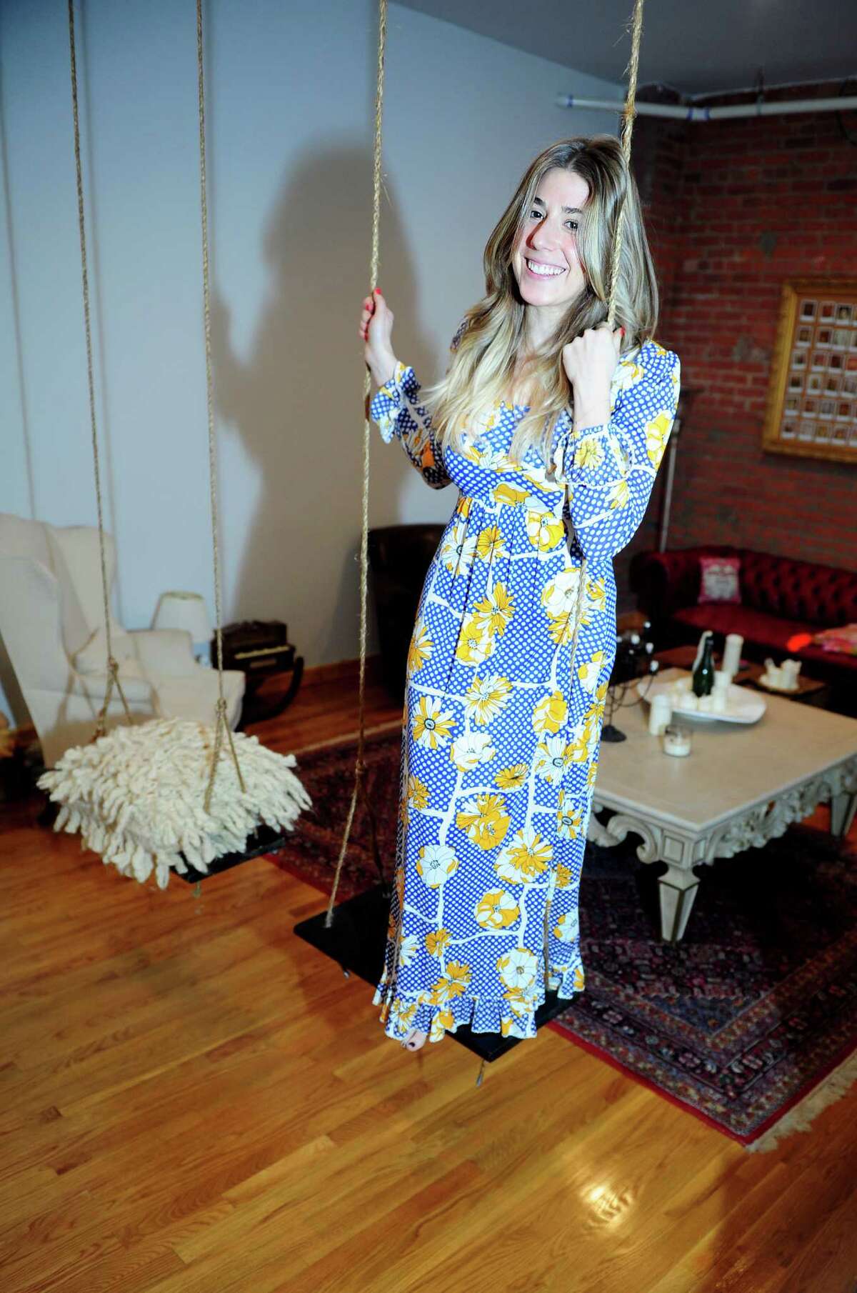 Avid thrift shop hunter Maddie Rhodes at home in Bridgeport, Conn. Rhodes is wearing a floral dress purchased at Stratfort Antiques for $45.