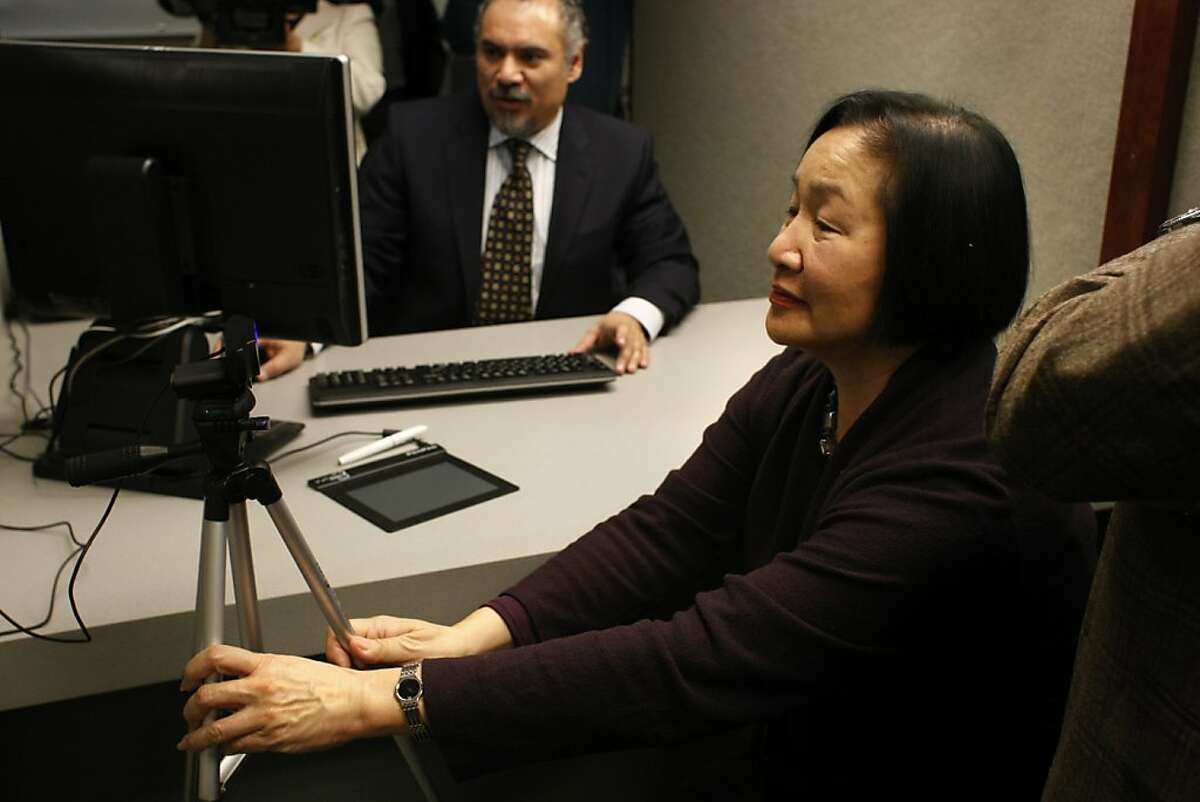 Oakland Mayor Jean Quan adjusts the camera to take her photo for the Oakland municipal identification card on Friday, Feb.1. The municipal identification doubles as a debit card and is aimed at undocumented immigrants as well as people who wish to not have their gender on the card.