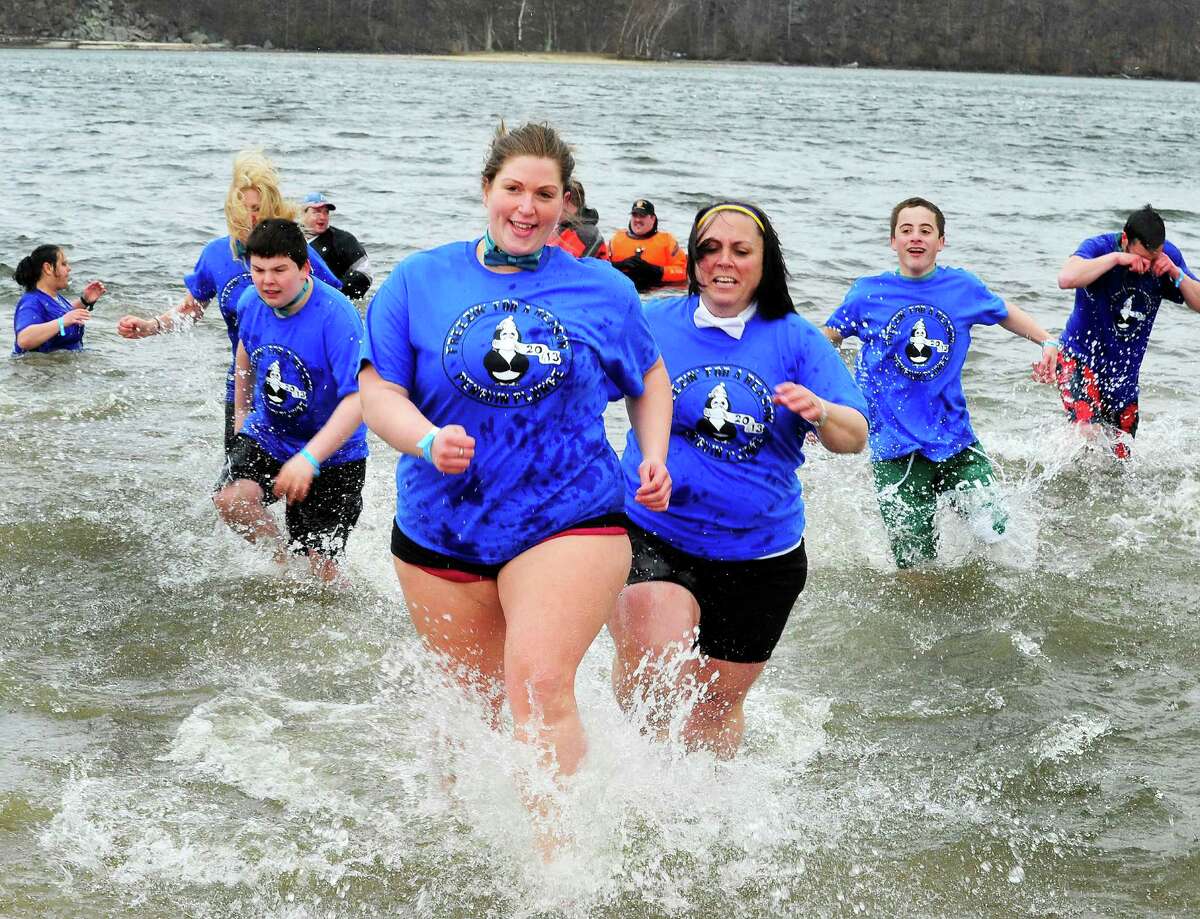 Ability Beyond Disability team members run from the water during the Penguin Plunge into Candlewood Lake at the Danbury Candlewood Park, in Conn. Saturday, March 23, 2013. The event was a fundraiser for local charities including the Connecticut Special Olympics.