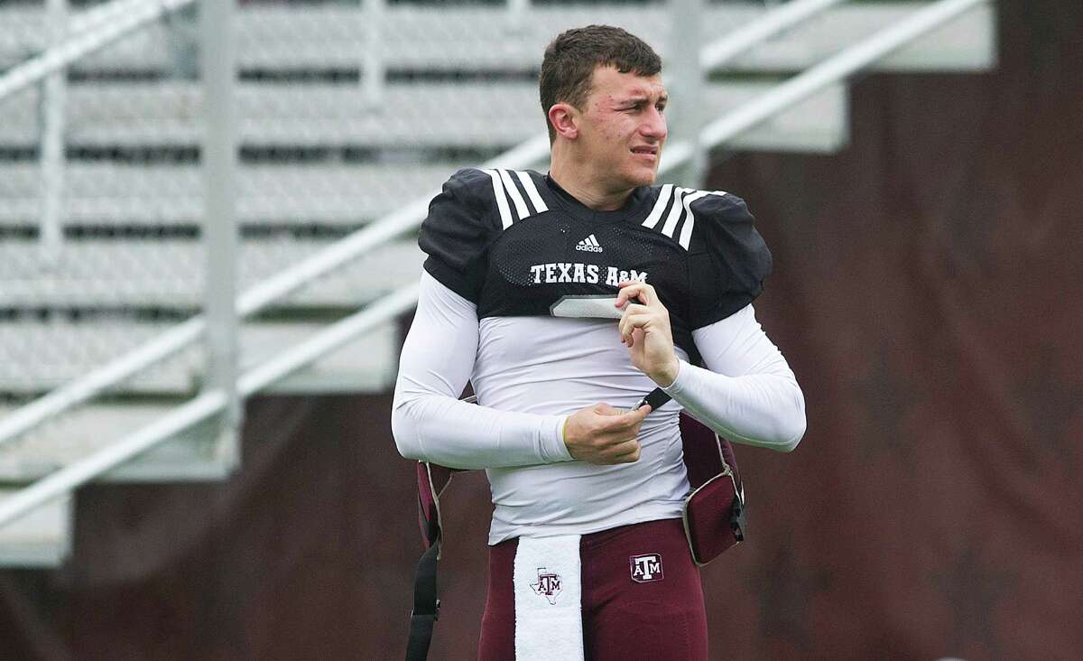 Texas A&M's Johnny Manziel buckles his pads before a scrimmage at spring NCAA college football practice at Kyle Field in College Station, Texas, Saturday, March 23, 2013. (AP Photo/Bryan-College Station Eagle, Stuart Villanueva)