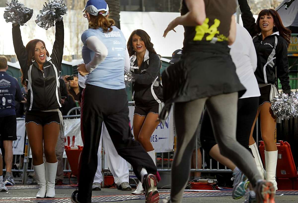 Oakland Raider cheerleaders welcomed 5K runners back to the finish line. The 2013 Oakland Running Festival featured a marathon, half marathon, relays, a 5K race and kids fun run all over the city on a fine spring day Sunday March 24, 2013.