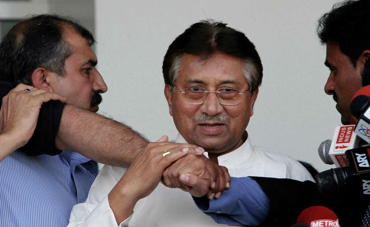 Former Pakistani President Pervez Musharraf, center, surrounded by guards, upon his arrival to Karachi airport, Pakistan, Sunday, March 24, 2013. Former Pakistani President Pervez Musharraf ended more than four years in self-exile Sunday with a flight to his homeland, seeking a possible political comeback in defiance of judicial probes and death threats from Taliban militants. (AP Photo/Shakil Adil)