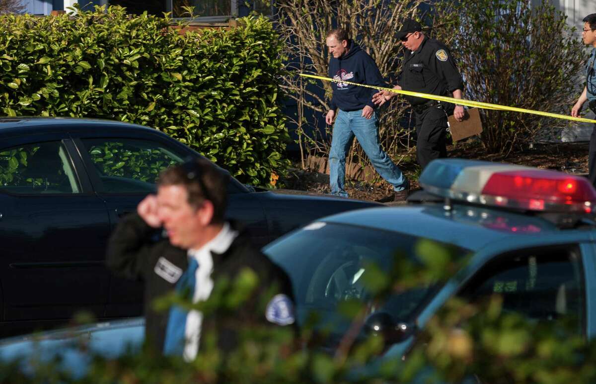 Police lead the suspected driver from the scene of a North Seattle car-pedestrian collision away from the crash site on Monday, March 25, 2013, near Nathan Eckstein Middle School in Seattle.