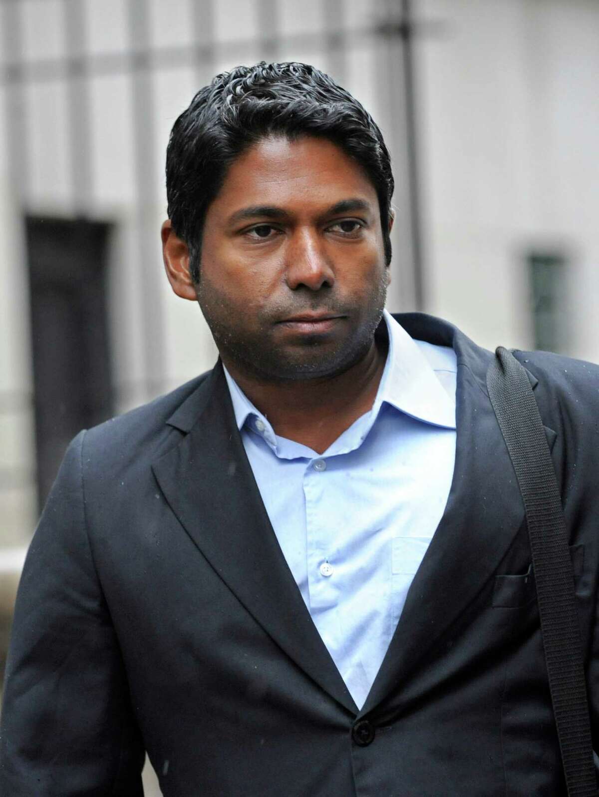 Rengan Rajaratnam exits Manhattan federal court, Monday, March 25, 2013, in New York. The brother of jailed one-time billionaire hedge fund boss Raj Rajaratnam entered a not guilty plea to federal insider trading charges. and was released on a one million dollar bond. (AP Photo/ Louis Lanzano)