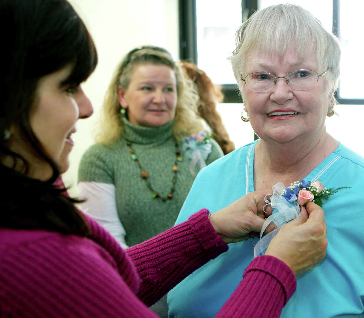 Lisa Smith, director of patient care services at New Milford Hospital, pins a corsage on registered nurse Carroll Linabury, who has been at the birthing center the longest of all staff members - 44 years. Linabury and other staff were honored March 21, 2013 for their work during a farewell party at the hospital, two days before the closing of the birthing center.