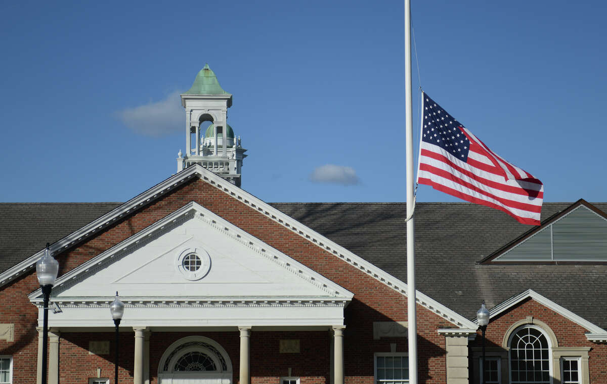 A flag at half-mast waves in front of the Newtown Municipal Center during the state police debriefing for families involved in the Sandy Hook shooting in Newtown, Conn. on Wednesday, March 27, 2013.