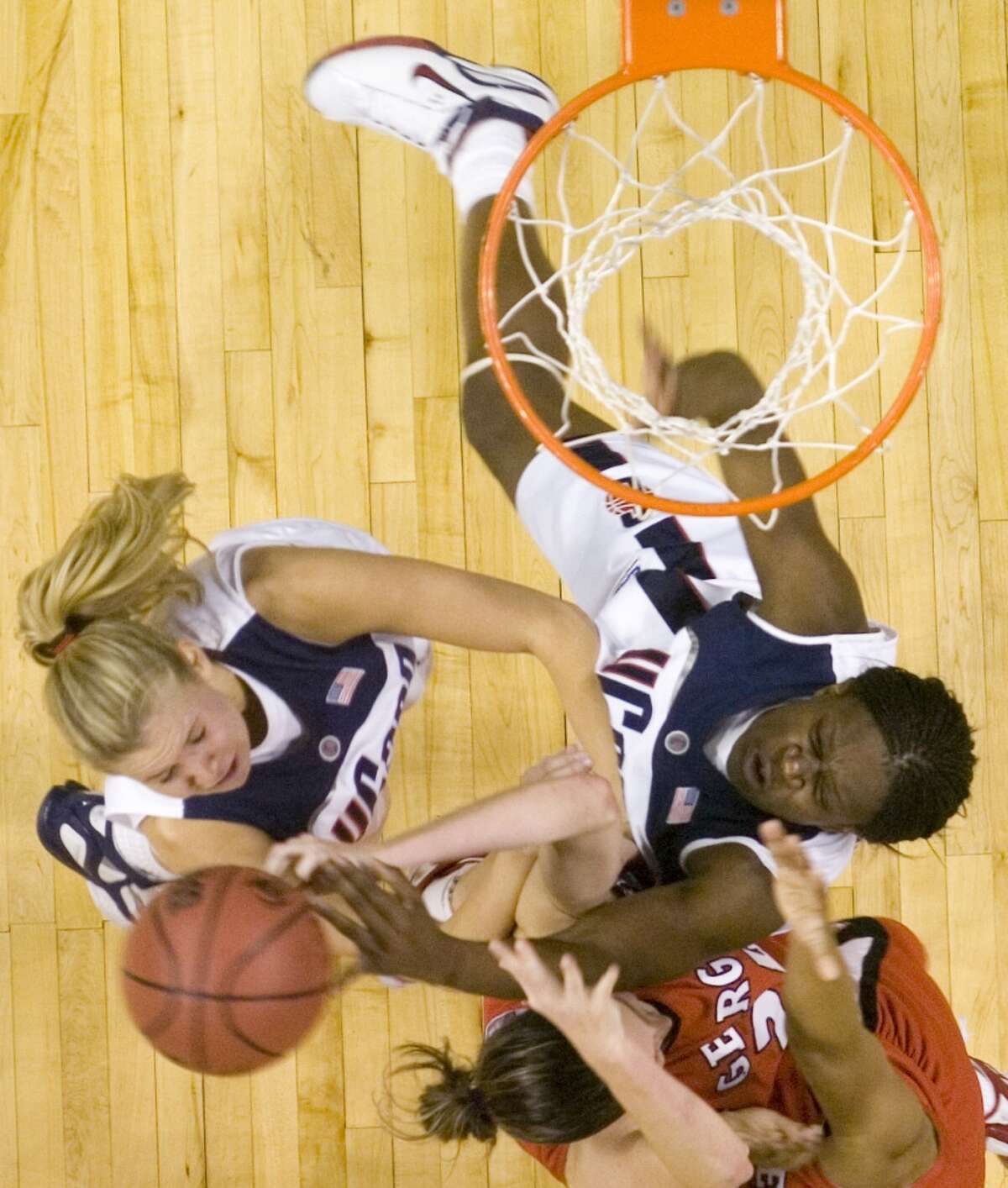Bridgeport_032606_ Connecticut's Ann Strother, left, Georgia's Megan Darrah, bottom, and Connecticut's Barbara Turner, right, go after a rebound during the 2006 NCAA Tournament Bridgeport Regional basketball tournament at the Arena at Harbor Yard in Bridgeport, Conn. on Sunday, March 26, 2006. Chris Preovolos/Stamford Advocate