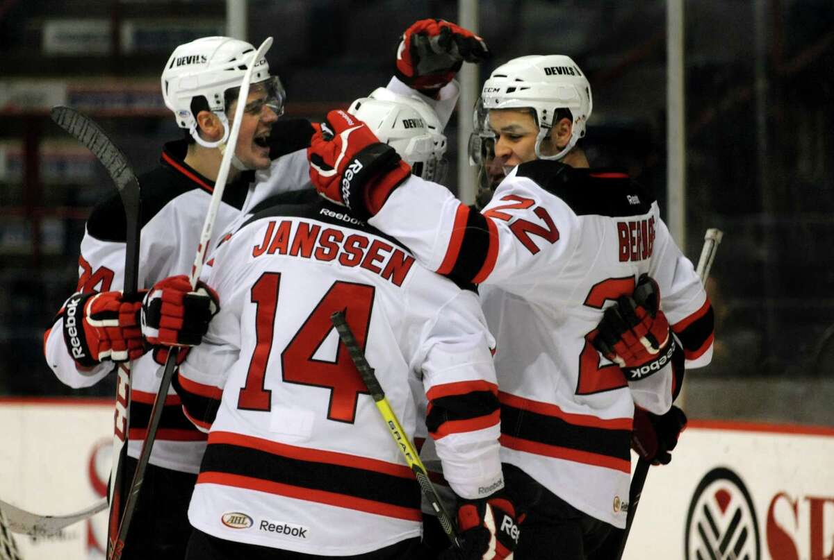 Devils' Eric Gelinas, left, celebrates a first-period goal by Cam Janssen, center, assisted by Jean-Sebastien Berube, right, during their hockey game against the Hershey Bears on Friday, March 29, 2013, at Times Union Center in Albany, N.Y. (Cindy Schultz / Times Union)